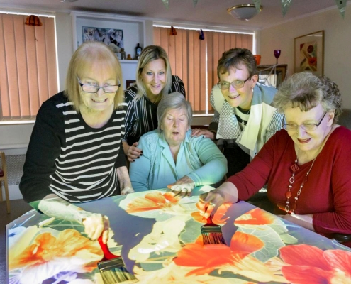 Care Home residents engaging with fun painting activity on an interactive sensory table