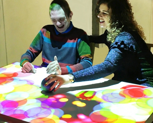 adults with learning difficulties having fun with activities on interactive sensory  table